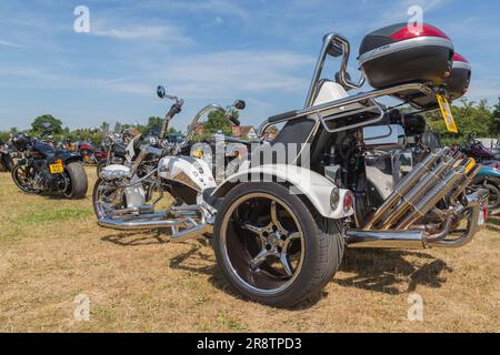 Ein Boom Trike zwischen Reihen von Motorrädern bei einer Motorrad-Rallye. Stockfoto