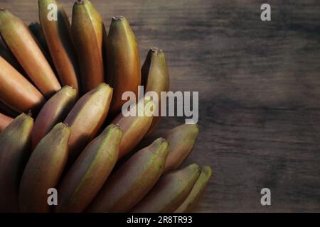 Leckere lila Bananen auf einem Holztisch, Blick von oben. Platz für Text Stockfoto