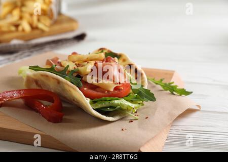 Köstliche Pita Wrap mit Jamon, Gemüse und Grüns auf Holztisch Stockfoto