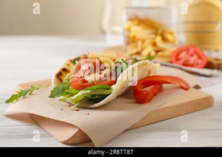 Köstliche Pita Wrap mit Jamon, Gemüse und Grüns auf Holztisch Stockfoto