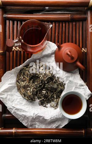 Flache Liegezusammensetzung mit pu-erh-Tee auf Holztablett. Traditionelle Zeremonie Stockfoto