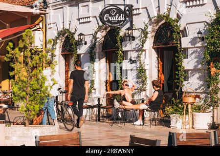 Touristen entspannen sich vor dem Oraldi Gebäck und Café auf Rruga Kolë Idromeno in Shkodër, Albanien Stockfoto