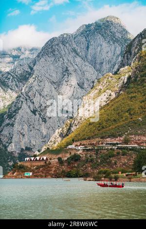 Gebirge überragen kleine Dörfer am Ufer des Koman-Sees, einem Reservoir, das am Fluss Drin im Norden Albaniens errichtet wurde Stockfoto