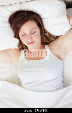 Schlafend, erholt und Frau im Bett von oben, friedlich und genießt ein ruhiges Nickerchen in ihrem Zuhause. Top Aussicht, träumend und weibliche Person in einem Schlafzimmer für Schlummerfunktion Stockfoto
