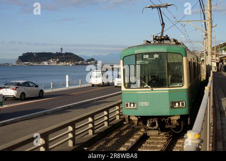 Enoshima Electric Railway Typ 1000 und Enoshima Island Stockfoto