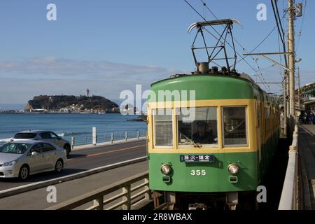 Enoshima Electric Railway Typ 300 und Enoshima Island Stockfoto