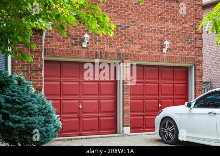 Doppeltes Garagentor mit Auffahrt in Toronto, Kanada. Garagentür im Luxushaus. Straßenfoto, niemand, selektiver Fokus Stockfoto