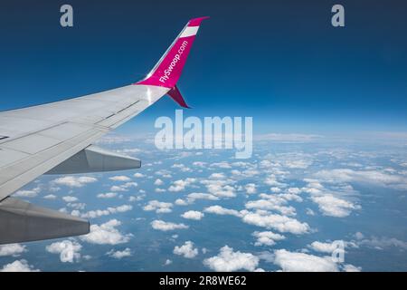 Foto eines Flugzeugflügels gegen den blauen Himmel, der über den Wolken fliegt. Eine Swoop Boeing 737-800 kurz nach dem Start vom Toronto International Airpo Stockfoto