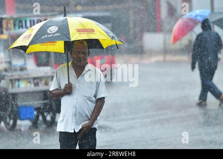 Pendler begeben sich bei starkem Regen in Agartala auf eine bewässerte Straße. Tripura, Indien. Stockfoto