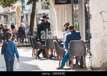 Ein Mann mit schwarzem Cowboyhut betritt ein Café in Pristina, Kosovo Stockfoto