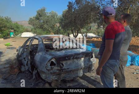 TURMUS AYYA, ISRAEL - JUNI 21: Palästinenser inspizieren ein Auto, das von israelischen Siedlern während eines Angriffs auf die Stadt Turmus Ayya in der Nähe der israelischen Siedlung Shilo am 21. Juni 2023 im Westjordanland, Israel, in Brand gesetzt wurde. Hunderte israelischer Siedler starteten einen Angriff auf die palästinensische Stadt Turmus Ayya, warfen Steine auf Häuser und zündeten Dutzende Autos und Häuser an. Kredit: Eddie Gerald/Alamy Live News Stockfoto