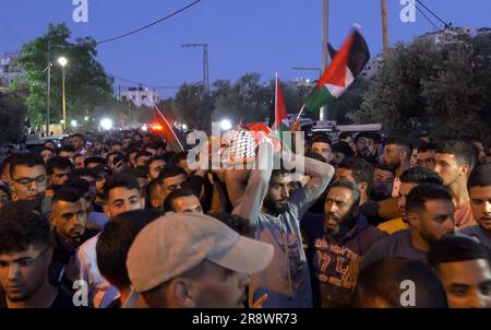 TURMUS AYYA, ISRAEL - JUNI 21: Die palästinensischen Trauernden tragen die Leiche eines 27-jährigen Mannes, der als Omar Qatin identifiziert wurde, der während eines Siedlerschlags durch die Stadt Turmus Ayya im Westjordanland, die sich am 21. Juni 2023 in der Nähe der israelischen Siedlung Shilo im Westjordanland, Israel, befindet, erschossen und getötet wurde. Hunderte israelischer Siedler starteten einen Angriff auf die palästinensische Stadt Turmus Ayya, warfen Steine auf Häuser und zündeten Dutzende Autos und Häuser an. Kredit: Eddie Gerald/Alamy Live News Stockfoto