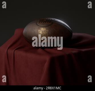 Eine 3D-Darstellung eines Rugby-Balls aus altem Leder mit einem goldenen Rugby-Logo der britischen und irischen Lions auf einem drapierten roten Stoff - 13. Februar 2023 in Brist Stockfoto