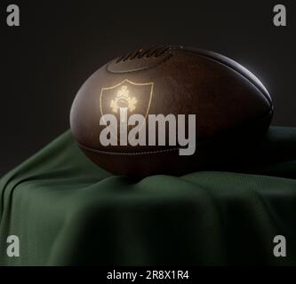 Eine 3D-Darstellung eines Rugby-Balls aus altem Leder mit einem goldenen irischen Rugby-Logo auf einem drapierten grünen Tuch - 13. Februar 2023 in Bristol, United Kin Stockfoto
