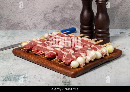 Lammspießfleisch. Barbecue-Fleisch aus Lammkeule auf einer Präsentationstafel aus Holz Stockfoto