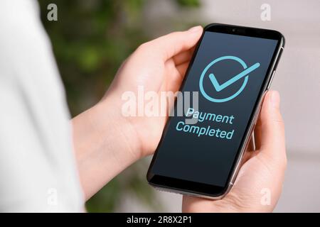 Frau hat erfolgreich mit einer Online-Banking-Anwendung auf einem Smartphone in Innenräumen bezahlt, Nahaufnahme Stockfoto