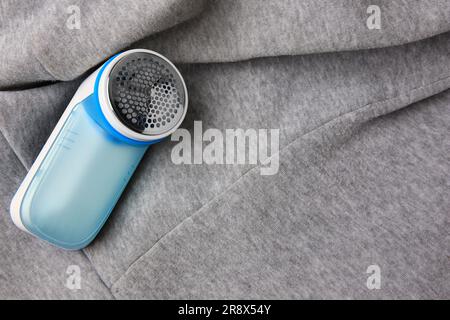 Moderner Rasierer auf hellgrauem Tuch mit Fusseln, über der Ansicht. Platz für Text Stockfoto
