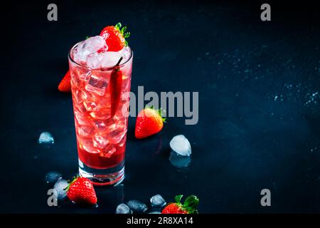 Rotes alkoholisches Cocktailgetränk mit Wodka, Grapefruitsaft, Erdbeeren, Zucker und heißem Chili-Pfeffer. Highball-Glas auf dunkelblauem Hintergrund Stockfoto