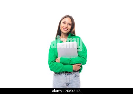 Süße junge, braunäugige, braunhaarige Karrierefrau mit Make-up in einer grünen Bluse arbeitet Remote im IT-Bereich Stockfoto