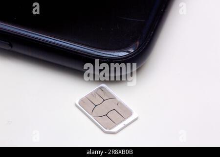 Berlin, Deutschland. 22. Juni 2023. Eine SIM-Karte liegt auf einem Tisch neben einem Smartphone. Kredit: Fernando Gutierrez-Juarez/dpa/Alamy Live News Stockfoto