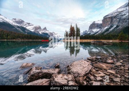 Wunderschöne weltberühmte und berühmte Spirit Island mit männlichen Touristen, die auf dem hölzernen Pier am Maligne Lake im Jasper-Nationalpark, Alberta, Kanada, spazieren Stockfoto