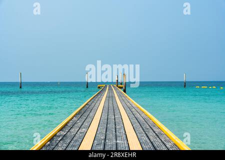 Der Pontongang schwimmt im Sommer auf dem tropischen Meer mit einer Säule Stockfoto