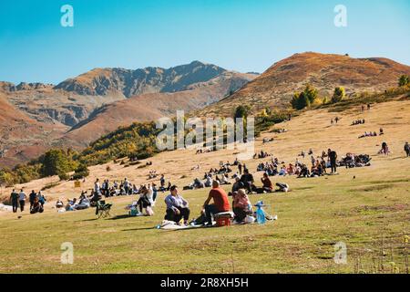 An einem sonnigen Sommerwochenende in Prevalla, einer Bergstadt im Kosovo, entspannen sich die Menschen auf den grasbedeckten Hängen des Prevalla Field Stockfoto