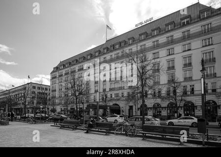 Berlin, Deutschland - 18. April 2023 : Blick auf das berühmte Adlon Hotel und die deutsche Nationalflagge in Berlin in Schwarz und Weiß Stockfoto