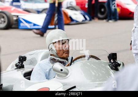 Rennfahrer Stirling Moss bereitet sich auf ein Rennen mit einem alten Mercedes-Benz beim Goodwood Festival of Speed in Großbritannien vor. Ältere Fahrer Stockfoto