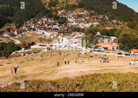 An einem sonnigen Sommerwochenende in Prevalla, einer Bergstadt im Kosovo, entspannen sich die Menschen auf den grasbedeckten Hängen des Prevalla Field Stockfoto