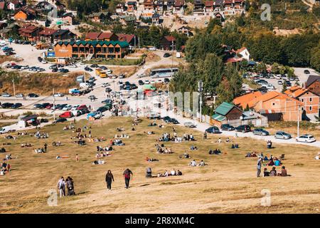 An einem sonnigen Sommerwochenende in Prevalla, einer Bergstadt im Kosovo, entspannen sich die Menschen auf den grasbedeckten Hängen des Prevalla Field Stockfoto