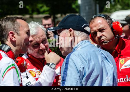 Der erfahrene Fahrer John Surtees spricht mit der aktuellen Formel-1-Ferrari-Pit-Crew beim Goodwood Festival of Speed. Ingenieure hören aufmerksam zu Stockfoto