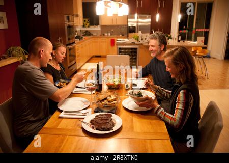Zwei Paare genießen ein Abendessen mit Bio-Produkten. Stockfoto
