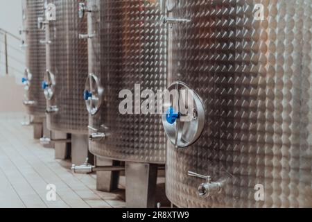 Moderne Weinbrennerei und Brauerei mit Brühkesselrohren und Edelstahltanks Stockfoto