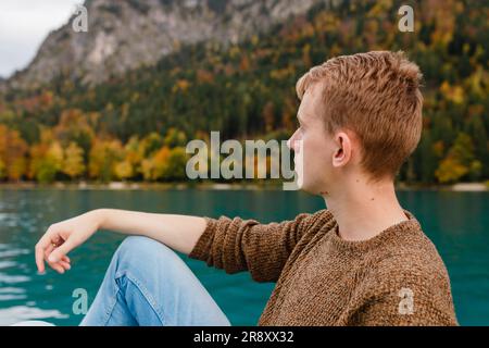 Junger Mann im Urlaub in der Nähe eines Bergsees in Osterreich Stockfoto