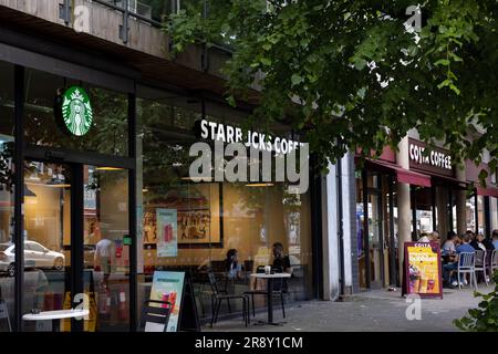 Costa und Starbucks Coffee Shops nebeneinander an einer London High Street: Uxbridge Road, Ealing Common Stockfoto