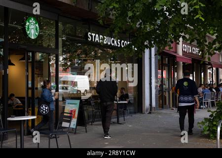 Costa und Starbucks Coffee Shops nebeneinander an einer London High Street: Uxbridge Road, Ealing Common Stockfoto