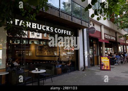 Costa und Starbucks Coffee Shops nebeneinander an einer London High Street: Uxbridge Road, Ealing Common Stockfoto