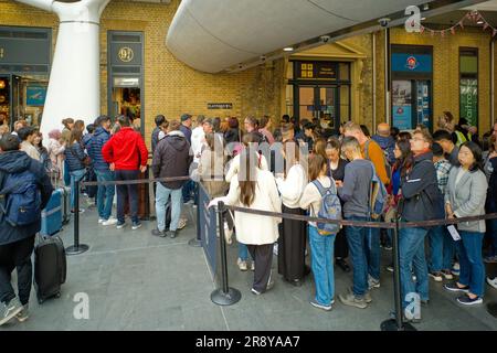 Lange Schlange von Menschen, die auf ein Foto von Plattform 9 3/4 in der Kings Cross Station warten Stockfoto