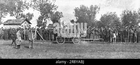 "L'Occupation Francaise en Bulgarie; Les prisonniers serbes du Camp de Haskovo, en Bulgarie, acclament la Mission franco-serbe venue leur annoncer la victoire et la delivrance La charrette, en avant de la cloture, servait chaque jour a emporter les morts et a rapporter le pain", 1918. Aus „L'Album de la Guerre 1914-1919, Band 2“ [L'Illustration, Paris, 1924]. Stockfoto