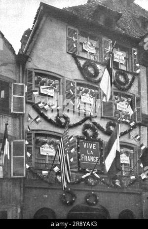 "Petain et Foch a Strasbourg; La parure de Fete de Strasbourg liberee: deux Facades ornees sur la Grande-Rue et sur le quai des Bateliers. Le soleil, qui avait rayonne le 22 novembre, pour l'entr&#xe9;e de Gouraud et de ses braves, manquait a la journee du 25. Mais l'Exaltation de la Population sut donner a la Fete de ce jour-la un caractere qui atteignit au Sublime',1918. Aus „L'Album de la Guerre 1914-1919, Band 2“ [L'Illustration, Paris, 1924]. Stockfoto