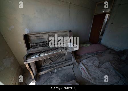 Ein Klavier in einer verlassenen Wohnung in der Pufferzone in Nikosia, Zypern. Als Mitglied der Friedenstruppe der Vereinten Nationen in Zypern hält die Haushaltskavallerie den Frieden und die Stabilität in einem Gebiet aufrecht, das auf die Öffentlichkeit beschränkt ist und seit der Waffenruhe im August 1974 den türkisch-zyprischen Norden und den griechisch-zyprischen Süden getrennt hat. Die Pufferzone erstreckt sich über etwa 180 km und umfasst verlassene Häuser und geschlossene Betriebe, aus der Zeit, als die Bewohner während der türkischen Invasion zur Flucht gezwungen wurden. Foto: Donnerstag, 22. Juni 2023. Stockfoto