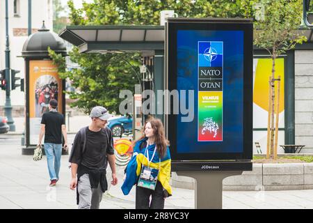 Werbebanner, das über den bevorstehenden NATO-Gipfel 2023 im Zentrum von Vilnius informiert, der Hauptstadt Litauens mit einem Paar mit ukrainischer Flagge Stockfoto