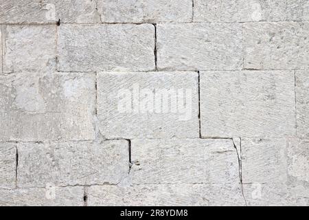 Tiefer Riss in einer alten mittelalterlichen Steinmauer aus großen Blöcken. Stockfoto