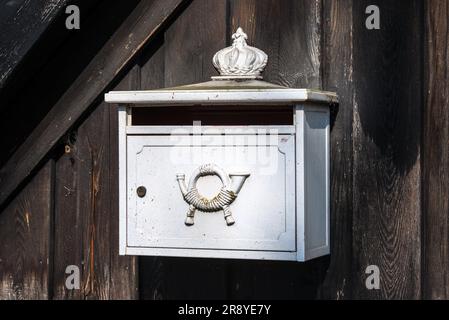 Briefkastenpostfach Metall Horn in Deutschland. Ländlicher Holzzaun - sonniger Tag. Stockfoto