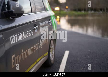 Seitenansicht eines isolierten Fahrzeugs der Umweltbehörde, das auf einem überfluteten Parkplatz geparkt ist und sich den Hinterrädern nähert. Stockfoto