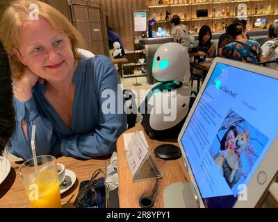 Tokio, Japan. 23. Juni 2023. Lisa Paus (Bündnis 90/die Grünen), Bundesministerin für Familie, besucht ein innovatives Robotercafé in Tokio und hört sich einen Avatarroboter an, der von zu Hause aus von einer an psychosomatischer Erkrankung leidenden japanischen Frau ferngesteuert wird. Kredit: Lars Nicolaysen/dpa/Alamy Live News Stockfoto