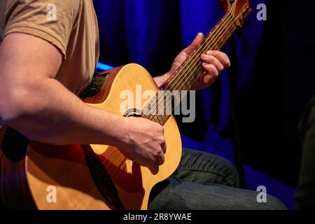 Bild von männlichen Händen, die Akustikgitarre spielen Stockfoto