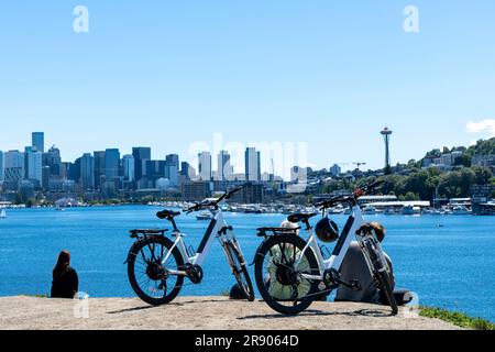 Seattle, WA, USA - Juli 2022; Panoramablick auf die Stadt und den Union Lake vom Kite Hill im Gas Works Park mit einigen Personen, die sich im Gras entspannen Stockfoto