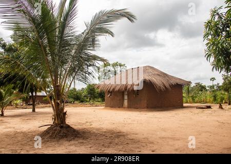 Typisches ländliches Schlammhaus in einem abgelegenen Dorf in Afrika mit Strohdach, sehr einfache und schlechte Lebensbedingungen Stockfoto